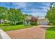 Inviting yellow home featuring a well-kept lawn, brick driveway, and attached garage, enhancing its charm at 305 Goddard Ln., Murrells Inlet, SC 29576