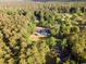 An expansive property is revealed from an aerial view, enveloped by a dense forest at 3173 Long Avenue Ext., Conway, SC 29526