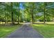 Long driveway leading to the house, framed by mature trees and green lawns at 3173 Long Avenue Ext., Conway, SC 29526