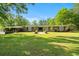 Expansive front yard with classic brick ranch home, mature trees, and manicured landscaping at 3173 Long Avenue Ext., Conway, SC 29526