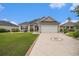 Charming single-story home featuring a well-manicured lawn and patterned driveway leading to a two-car garage at 325 Galway Ct., Longs, SC 29568