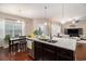 Open kitchen with dark cabinets, granite island, and stainless appliances, seamlessly connecting to dining and living areas at 325 Galway Ct., Longs, SC 29568