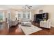 Inviting living room with hardwood floors, large windows, ceiling fan, and comfortable seating arrangement at 325 Galway Ct., Longs, SC 29568