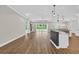 Open-concept living space with a kitchen island, wood floors, and modern lighting at 3995 Tillmond Dr., Conway, SC 29526