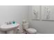 Cozy half bathroom featuring a pedestal sink, toilet, and neutral wall decor at 406 Glade Ct., Loris, SC 29569