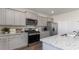 Bright kitchen with grey cabinets, stainless steel appliances, and granite countertops at 406 Glade Ct., Loris, SC 29569