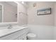 Clean, all-white bathroom featuring a vanity, toilet, and beach-themed decor, creating a refreshing ambiance at 415 Ocean Creek Dr. # 2161, Myrtle Beach, SC 29572