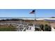 Beautiful beach view with American flag, scenic dunes, and accessible boardwalk, inviting coastal charm and accessibility at 415 Ocean Creek Dr. # 2161, Myrtle Beach, SC 29572