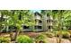 Beautiful three-story condo building with screened-in porches, surrounded by trees and lush landscaping at 415 Ocean Creek Dr. # 2161, Myrtle Beach, SC 29572