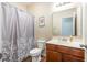 Bathroom with wood cabinets, a mirror, a toilet, and a shower with a curtain at 436 Cotton Grass Dr., Loris, SC 29569