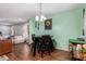 Dining area features modern table, green walls, and wood floors adjacent to the living area at 436 Cotton Grass Dr., Loris, SC 29569