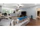 Open-concept living area with hardwood floors, a sectional couch, and a large TV with fireplace at 436 Cotton Grass Dr., Loris, SC 29569