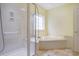 Well-lit bathroom features a separate shower and a tub under a window, creating a spa-like atmosphere at 44 Hamby Dr., Pawleys Island, SC 29585