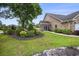 Brick home with manicured lawn, mature landscaping, and inviting sunroom extension for outdoor enjoyment at 44 Hamby Dr., Pawleys Island, SC 29585