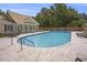 Community pool with lounge chairs and tables in a fenced area with lots of mature trees providing shade at 44 Hamby Dr., Pawleys Island, SC 29585