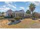 Spacious backyard featuring a sunroom extension and pergola with decorative landscaping at 4608 Grovecrest Circle, North Myrtle Beach, SC 29582
