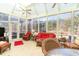 Bright sunroom with wicker furniture, ceiling fans, and large windows overlooking the lush outdoors at 4608 Grovecrest Circle, North Myrtle Beach, SC 29582