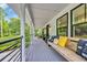 Spacious covered porch with comfortable seating, charming pillows, and stylish decor at 476 Lakeshore Dr., Pawleys Island, SC 29585