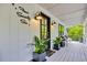 Inviting front porch with stylish sconces, plants, and a cozy bench at 476 Lakeshore Dr., Pawleys Island, SC 29585