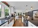 Bright kitchen features stainless steel appliances, farmhouse sink, black countertops and an open concept dining area at 476 Lakeshore Dr., Pawleys Island, SC 29585