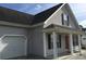 Home exterior featuring gray siding, black shutters, a red door, and an attached garage at 4949 Southgate Pkwy., Myrtle Beach, SC 29579