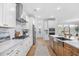 Bright kitchen features a stainless steel range hood, white cabinets, stainless steel appliances and an island with a sink at 503 Rose Fountain Dr., Myrtle Beach, SC 29579