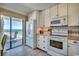 Kitchen with white cabinets and appliances offering ocean view access to the balcony from sliding glass doors at 5905 S Kings Hwy. # 1717, Myrtle Beach, SC 29575