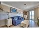 Cozy living room with comfortable seating, white wainscoting, and access to a balcony with ocean views at 5905 S Kings Hwy. # 1717, Myrtle Beach, SC 29575