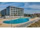 Large community pool with plenty of lounge chairs and beautifully landscaped surroundings offers a relaxing experience at 5905 S Kings Hwy. # 1717, Myrtle Beach, SC 29575