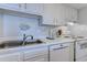 Kitchen area showcasing stainless steel sink, white cabinets and laminate floors at 601 Mitchell Dr. # 806, Myrtle Beach, SC 29577