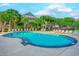 Community pool surrounded by lounge chairs and palm trees with view of apartment buildings at 601 Mitchell Dr. # 806, Myrtle Beach, SC 29577