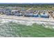 Picturesque aerial shot of a coastal community and the ocean with waves crashing on the shore at 720 N Waccamaw Dr. # 202, Garden City Beach, SC 29576