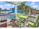 Relaxing balcony area with table and chairs overlooking the ocean, pool, and palm trees at 720 N Waccamaw Dr. # 202, Garden City Beach, SC 29576