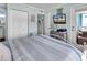 Cozy bedroom with comfortable bed, television, and a doorway leading to a balcony at 720 N Waccamaw Dr. # 202, Garden City Beach, SC 29576