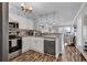 Charming kitchen featuring white cabinetry, granite countertops, stainless steel appliances, and views of the living room at 720 N Waccamaw Dr. # 202, Garden City Beach, SC 29576