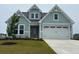 Charming coastal-style home featuring a two-car garage and light-blue shingles with clean landscaping at 732 St. Vincent Loop, Little River, SC 29566