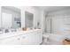 Modern bathroom with double vanity, white cabinets, and shower-tub combo at 738 Chazen Way, Longs, SC 29568