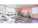 Inviting living room filled with natural light, showcasing a white sofa, striped rug, and coral-colored accent wall at 738 Chazen Way, Longs, SC 29568