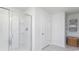 Modern tiled shower with glass door and integrated shelving next to a closet with additional shelving for storage at 738 Chazen Way, Longs, SC 29568