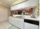 A kitchen with white cabinets, a double sink, and a view into the adjacent living areas at 75-4 Weehawka Way # 4, Pawleys Island, SC 29585