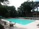 Large pool surrounded by lots of trees and lounging chairs at 75-4 Weehawka Way # 4, Pawleys Island, SC 29585