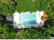 Aerial view of a beautiful community pool surrounded by lush green trees and lounge chairs at 75-4 Weehawka Way # 4, Pawleys Island, SC 29585