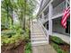 Exterior view of steps to a condo's entrance, surrounded by lush landscaping and tall trees at 75-4 Weehawka Way # 4, Pawleys Island, SC 29585