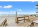 Stairs lead to a beautiful sandy beach with ocean views under a blue, cloudy sky at 807 N Waccamaw Dr., Murrells Inlet, SC 29576