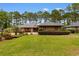 Charming brick home boasts a lush lawn, mature trees, and meticulously maintained landscaping at 8207 Timber Ridge Rd., Conway, SC 29526