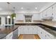 Well-lit kitchen with a view of the backyard offers white cabinets, granite counters, and stainless appliances at 8207 Timber Ridge Rd., Conway, SC 29526