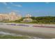 Expansive beach view featuring rows of colorful umbrellas and nearby condos, with clubhouse nearby at 9485 Ronda Ct., Myrtle Beach, SC 29579