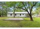 Backyard of a home with a concrete pad, white painted exterior, and trees at 96 Middleton Rd., Andrews, SC 29510
