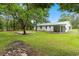 Expansive backyard with mature trees, a concrete pad, and a covered porch at 96 Middleton Rd., Andrews, SC 29510