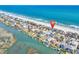 An aerial view showcasing coastal homes nestled between the ocean and marsh at 969 S Waccamaw Dr., Garden City Beach, SC 29576